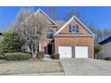 Classic brick home featuring an attached two-car garage and manicured landscaping, creating curb appeal at 1924 Wilkenson Xing, Marietta, GA 30066