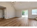 Vaulted living room with wood flooring and sliding glass doors to the outside at 210 Riveredge Way, Mcdonough, GA 30252