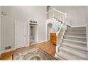 Bright foyer with hardwood floors, a staircase with white railing, and a view into a hallway at 542 Fairway Dr, Woodstock, GA 30189