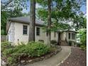 Side view of a tan stucco home showcasing manicured landscaping and stone-lined walkway at 3261 Stonecreek Ct, Suwanee, GA 30024
