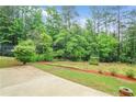 Expansive backyard featuring lush greenery and a concrete patio, perfect for outdoor relaxation at 3179 Woodward Down Trl, Buford, GA 30519