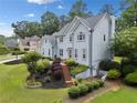 Side angle of a beautiful two-story home with a well-maintained yard, lush landscaping, and a inviting walkway at 5711 Brynwood Nw Cir, Acworth, GA 30101