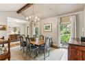 Chic dining room with a wooden table and chairs beneath a decorative chandelier, and sunlit windows at 80 Maryeanna Dr, Sandy Springs, GA 30342