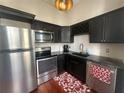 Modern kitchen featuring stainless steel appliances, black cabinets, and hardwood floors at 20 Marietta Nw St # 13C, Atlanta, GA 30303
