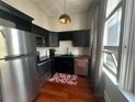 Cozy kitchen featuring stainless steel appliances, black cabinets, and hardwood floors at 20 Marietta Nw St # 13C, Atlanta, GA 30303