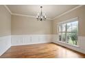 Elegant dining room with hardwood floors, wainscoting, and a large window at 2720 Tuscany Park Dr, Lawrenceville, GA 30043