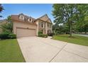 Two-story home featuring a two-car garage, stone accents, and a well-kept front lawn at 2747 Harper Woods Dr, Marietta, GA 30062