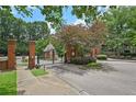 Brick and iron gate to the 350 McGill Place community with mature trees and professional landscaping at 514 Mcgill Ne Pl, Atlanta, GA 30312