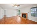 Spacious living room with wood floors, a brick fireplace, ceiling fan, and access to the balcony at 514 Mcgill Ne Pl, Atlanta, GA 30312