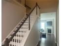 Interior shot of staircase with dark wood handrail, white risers and balusters, and hardwood floors at 209 Ellis Ln, Woodstock, GA 30189