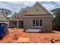 Newly built two-story home with brick facade and a well-lit interior under a cloudy sky at 2753 S Waterworks Rd, Buford, GA 30518