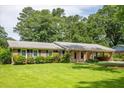 Well-kept single-story home featuring a green lawn, tidy shrubs, and a convenient covered parking area at 4150 Glenn St, Powder Springs, GA 30127