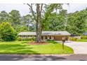 Inviting single-story home with lush green lawn and a large tree, creating a picturesque and serene setting at 4150 Glenn St, Powder Springs, GA 30127