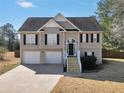 Inviting two-story home features a two-car garage and charming front porch with a well-manicured lawn at 8870 Dornoch Cir, Winston, GA 30187