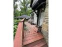 View of the wooden front porch featuring red wood, steps, and wooded scenery at 2463 Stone Rd, East Point, GA 30344
