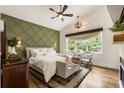 Inviting main bedroom featuring an accent wall, large windows with natural light, and stylish decor at 221 Brooke Dr., Alpharetta, GA 30009