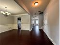 Spacious dining room featuring dark hardwood floors, elegant wainscoting, and modern chandelier at 3522 Fallen Oak Dr, Buford, GA 30519