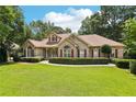 Charming brick home with a lush lawn, beautiful landscaping, and red window shutters under a sunny blue sky at 8110 Lakemont Close, Mcdonough, GA 30253