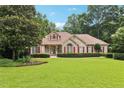 Beautiful brick home with well-maintained lawn and mature trees provides curb appeal at 8110 Lakemont Close, Mcdonough, GA 30253