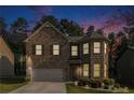 Charming two-story brick home at dusk with manicured lawn and attached garage at 10137 Cormac St, Jonesboro, GA 30238