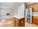Modern kitchen featuring stainless steel refrigerator, island, hardwood floors, and fireplace at 3515 Mcclure Woods Dr, Duluth, GA 30096
