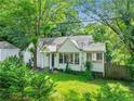 Quaint white brick home featuring a well-maintained lawn and lush greenery at 511 Ashburton Ave, Decatur, GA 30032