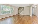 Spacious living room with gleaming hardwood floors, staircase, and large front window at 511 Ashburton Ave, Decatur, GA 30032