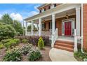 Inviting front porch with white columns, flower boxes, and a red front door surrounded by lush landscaping at 1140 Promontory Drive, Marietta, GA 30062