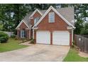 Charming brick home featuring a two-car garage, manicured lawn, and classic architectural details at 565 Saint James Ct, Lawrenceville, GA 30044