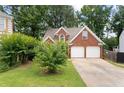 Two-story brick home with a two-car garage and a well-maintained front yard at 565 Saint James Ct, Lawrenceville, GA 30044