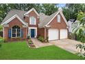 Charming two-story brick home with a well-manicured lawn and a two-car garage at 565 Saint James Ct, Lawrenceville, GA 30044
