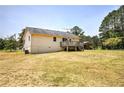 Large backyard with mature trees, storage space, and covered deck at 668 Spring Place Ne Rd, White, GA 30184