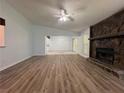 Spacious living room featuring new wood flooring and a striking stone fireplace at 8249 Creekline Ct, Riverdale, GA 30274