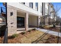 Covered outdoor patio with brick columns and flooring, recessed lighting, and sliding glass doors at 350 Olmstead Way # 29, Alpharetta, GA 30022