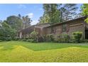 Charming single-story home featuring a large front yard with mature trees and natural landscaping at 267 Firecreek Rdg, Lawrenceville, GA 30046