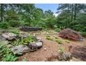 Picturesque landscaped backyard featuring a rock pond and well-manicured flower beds at 5065 Nesbit Ferry Ln, Atlanta, GA 30350
