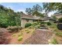 View of home's exterior elevation showcasing front of house and beautiful yard with mature trees and flowers at 5065 Nesbit Ferry Ln, Atlanta, GA 30350