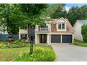 Inviting two-story home with a balcony, manicured lawn, and a two-car garage at 1086 Erie Cir, Stone Mountain, GA 30087