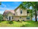 Back exterior view of a two-story home showcasing a large yard and mature trees at 1086 Erie Cir, Stone Mountain, GA 30087