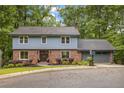 Traditional two-story home with brick and vinyl siding, a well-kept lawn, and an attached garage at 2892 Guinevere Ne Dr, Atlanta, GA 30345