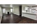 Open-concept living area with wood floors, fireplace, and a modern kitchen with white cabinets at 15 Harlan Rd, Atlanta, GA 30311