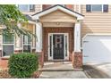 Inviting front entry with brick accents and a decorative wreath on the black front door at 316 Sierra Ct, Mcdonough, GA 30253