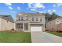 Inviting two-story brick home with a covered front porch and a two-car garage at 619 Leafy Branch Way, Mcdonough, GA 30253