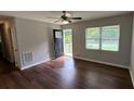 Cozy living room featuring hardwood floors, a modern ceiling fan, and lots of natural light at 38 Royce Dr, Jonesboro, GA 30238