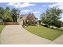 Beautiful brick home with a long driveway, manicured lawn, and mature trees in a desirable neighborhood at 4320 Cody Ct, Cumming, GA 30040