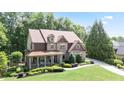 Charming brick two-story home with a covered front porch and well-manicured landscaping at 103 Millstone Way, Canton, GA 30115