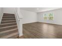 Spacious room with hardwood floors and staircase access to upper level at 1204 Arnhem Dr, Hampton, GA 30228