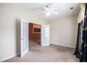 Bedroom with neutral carpet, a ceiling fan, and a view into the kitchen through french doors at 4200 Vinca Way, Union City, GA 30291