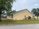 Side view of yellow single-story home with manicured lawn, small shrubs, and mulch at 4200 Vinca Way, Union City, GA 30291
