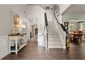 Inviting foyer with hardwood floors, staircase, and stylish console table, creating an open, airy feel at 5885 Millstone Dr, Cumming, GA 30028